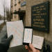 Photographic flat-lay planning scene near a window overlooking a Chelyabinsk street: on a dark