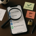 Smartphone on a desk shows a generic messaging app with Cyrillic betting channels; a